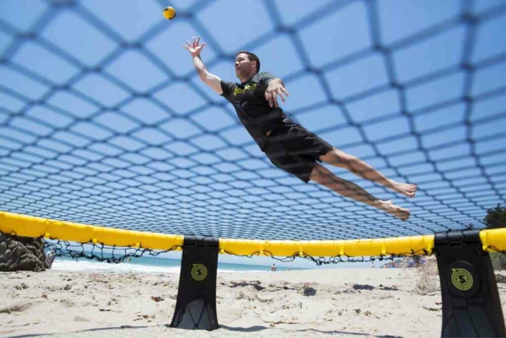 Playing spikeball 1v1 on a beach