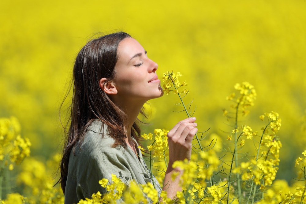 A woman smelling flowers.