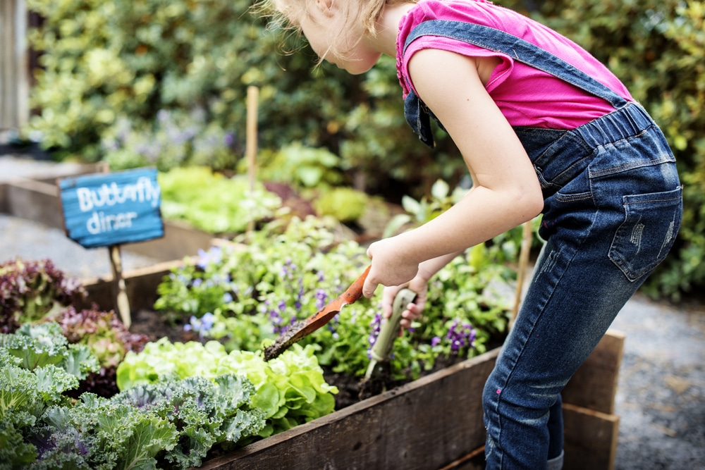 A girl gardening with some tools.