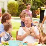 A multigenerational family having a good meal outside.