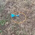 A blue lawn dart in a circle on the ground.