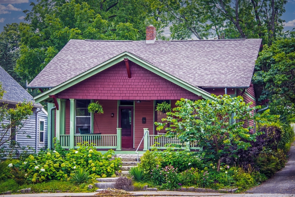 A red house with a garden out front.