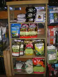 Shelves of bagged potting mixes and soil products in a garden centre, with several brands and blend labels visible.